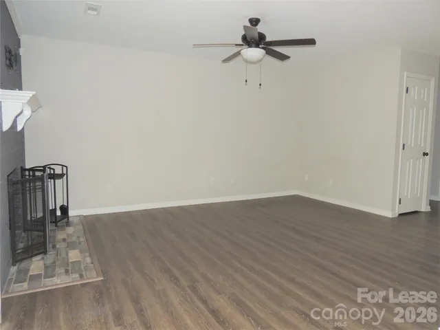 a view of a room with wooden floor and ceiling fan