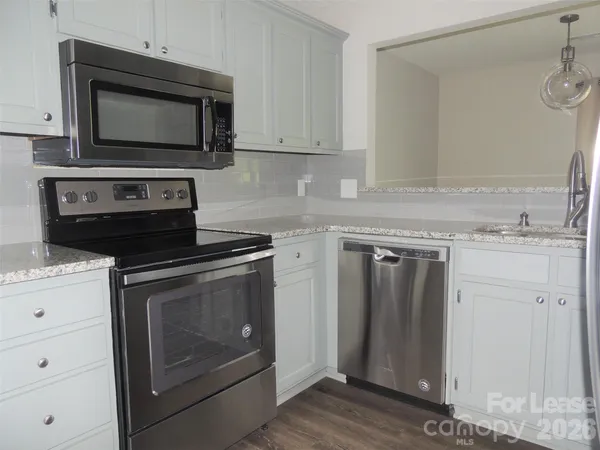 a kitchen with granite countertop a stove and a microwave