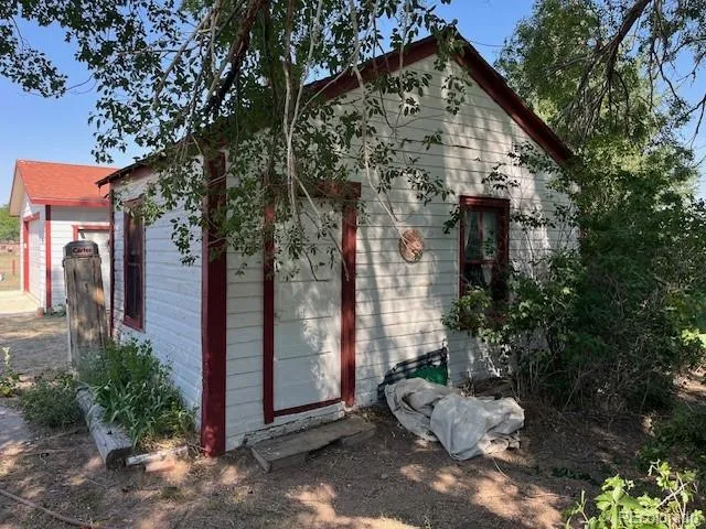 a view of a small house with a tree in front