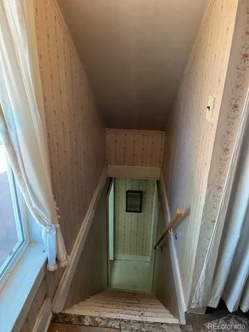 a bed sitting in a spacious bedroom next to a window