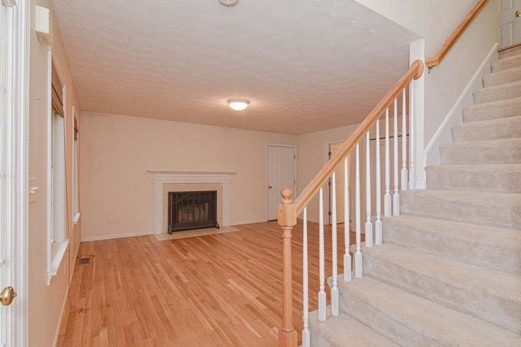 21 Shore Drive Upton, MA 01568 - Photo 4 of 29 a view of an empty room with wooden floor stairs and a window