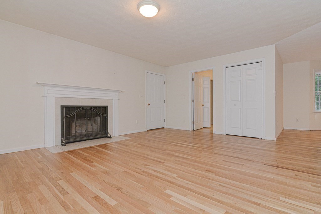 21 Shore Drive Upton, MA 01568 - Photo 5 of 29 a view of empty room with wooden floor and fireplace