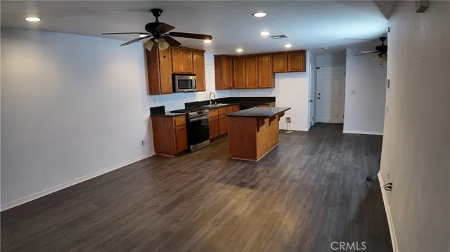 a kitchen with granite countertop a stove a sink and a refrigerator