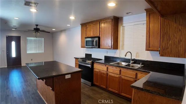 a kitchen with granite countertop a sink stove and cabinets
