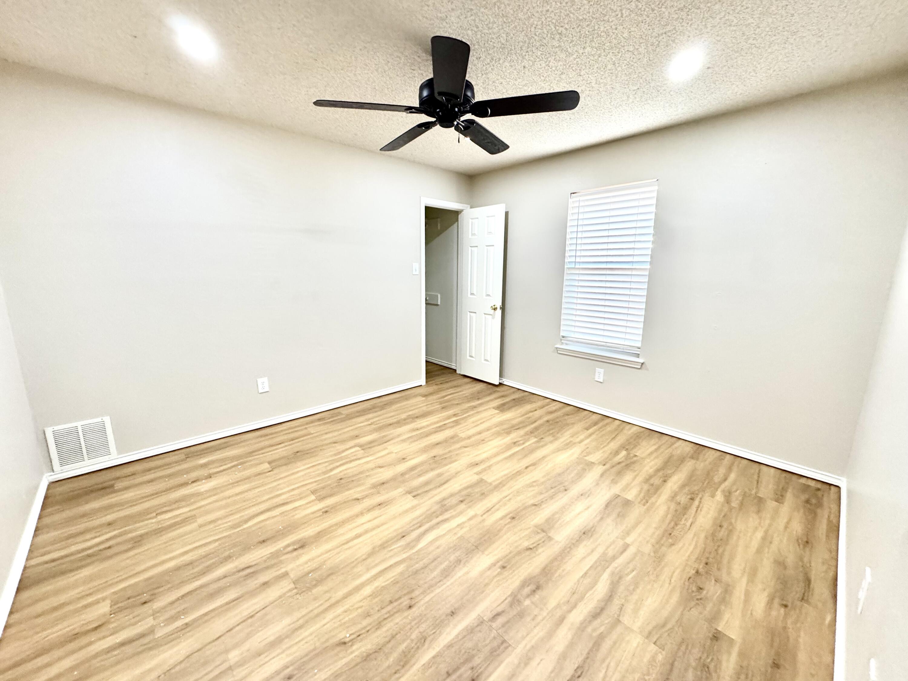 6536 7th Street Lubbock, TX 79416 - Photo 17 of 20 a view of empty room with wooden floor and fan