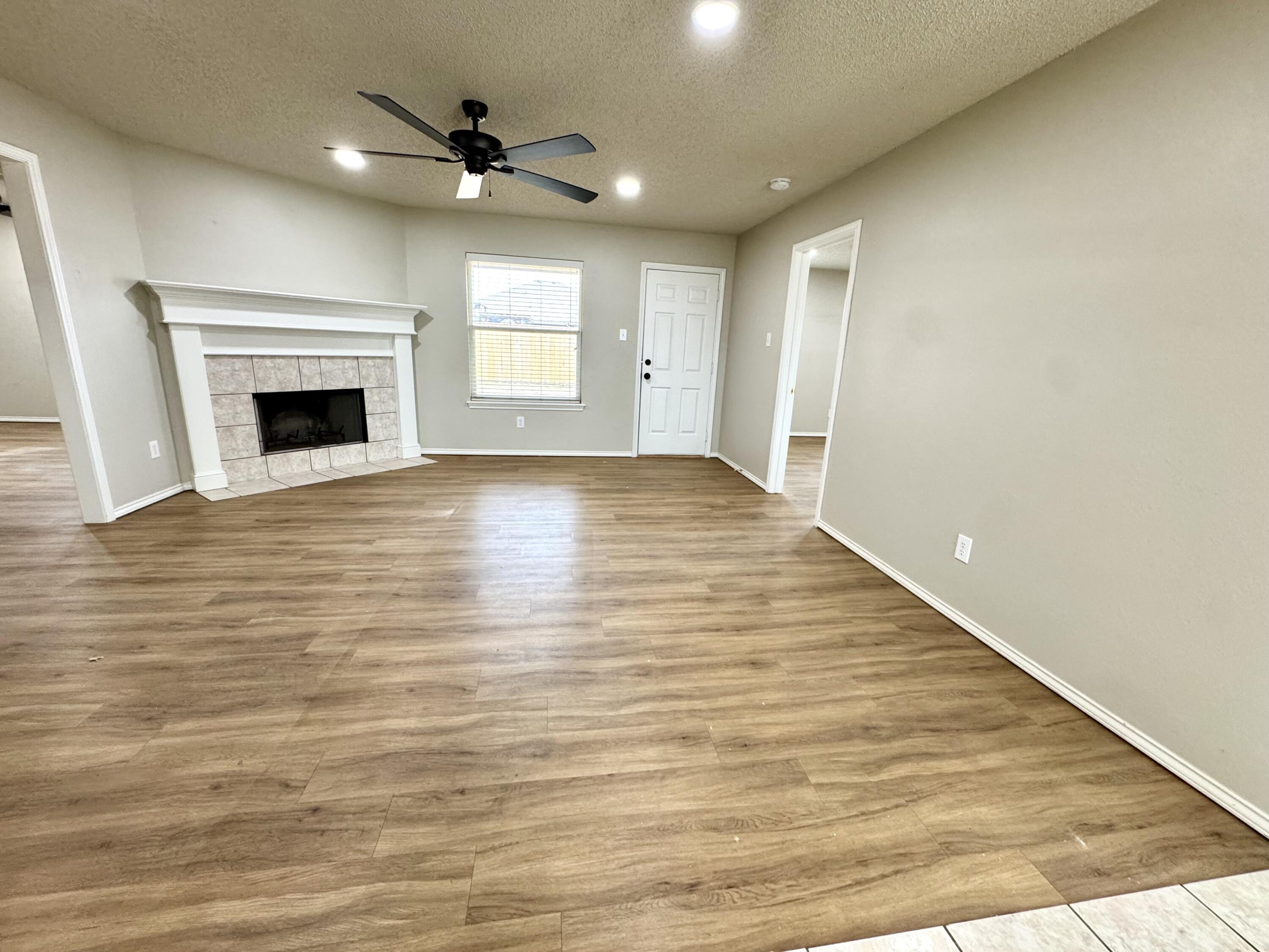 6536 7th Street Lubbock, TX 79416 - Photo 2 of 20 wooden floor in an empty room with a fireplace