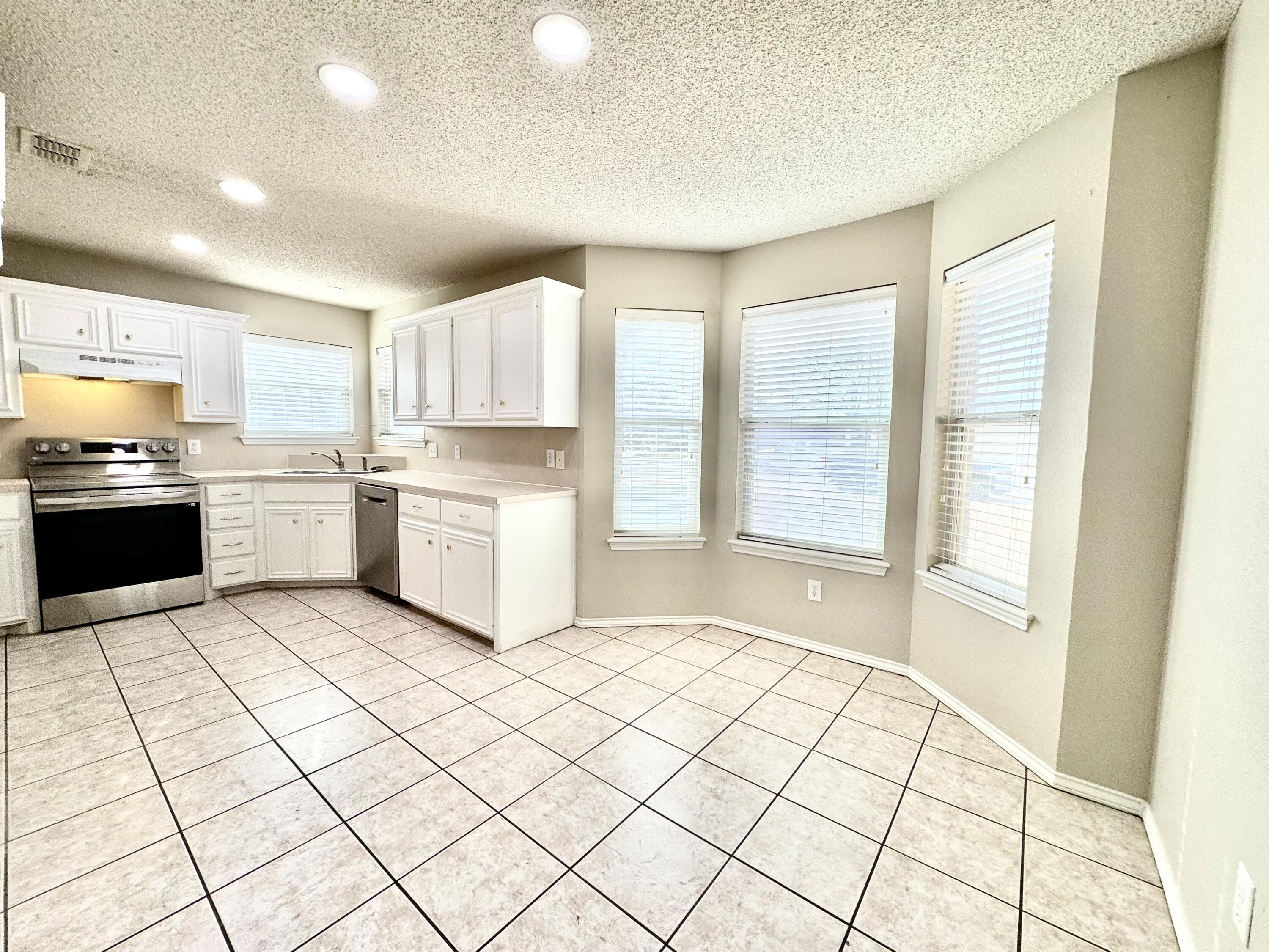 6536 7th Street Lubbock, TX 79416 - Photo 5 of 20 a kitchen with a stove a sink and a refrigerator