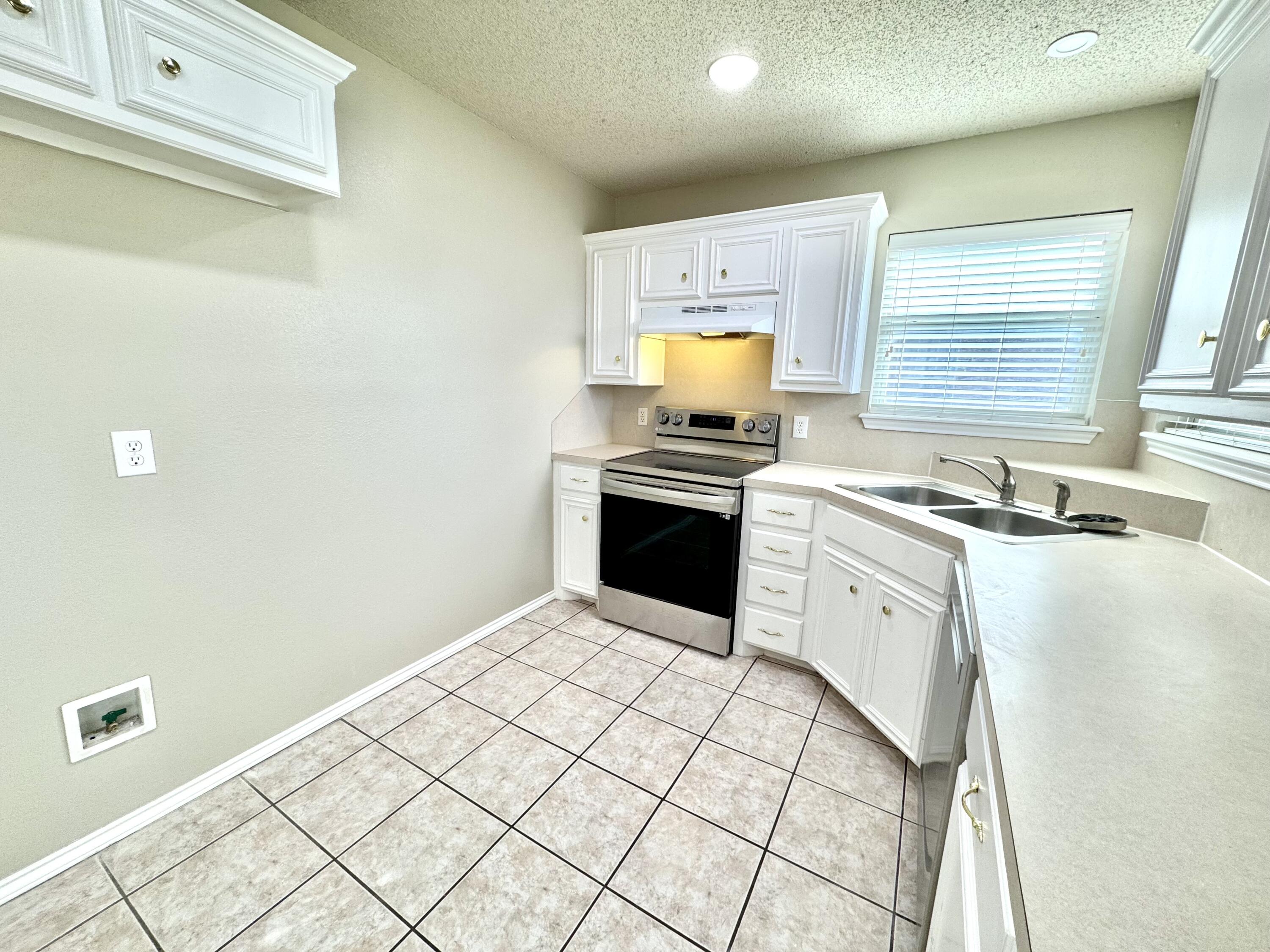 6536 7th Street Lubbock, TX 79416 - Photo 8 of 20 a kitchen with a stove a sink and a refrigerator