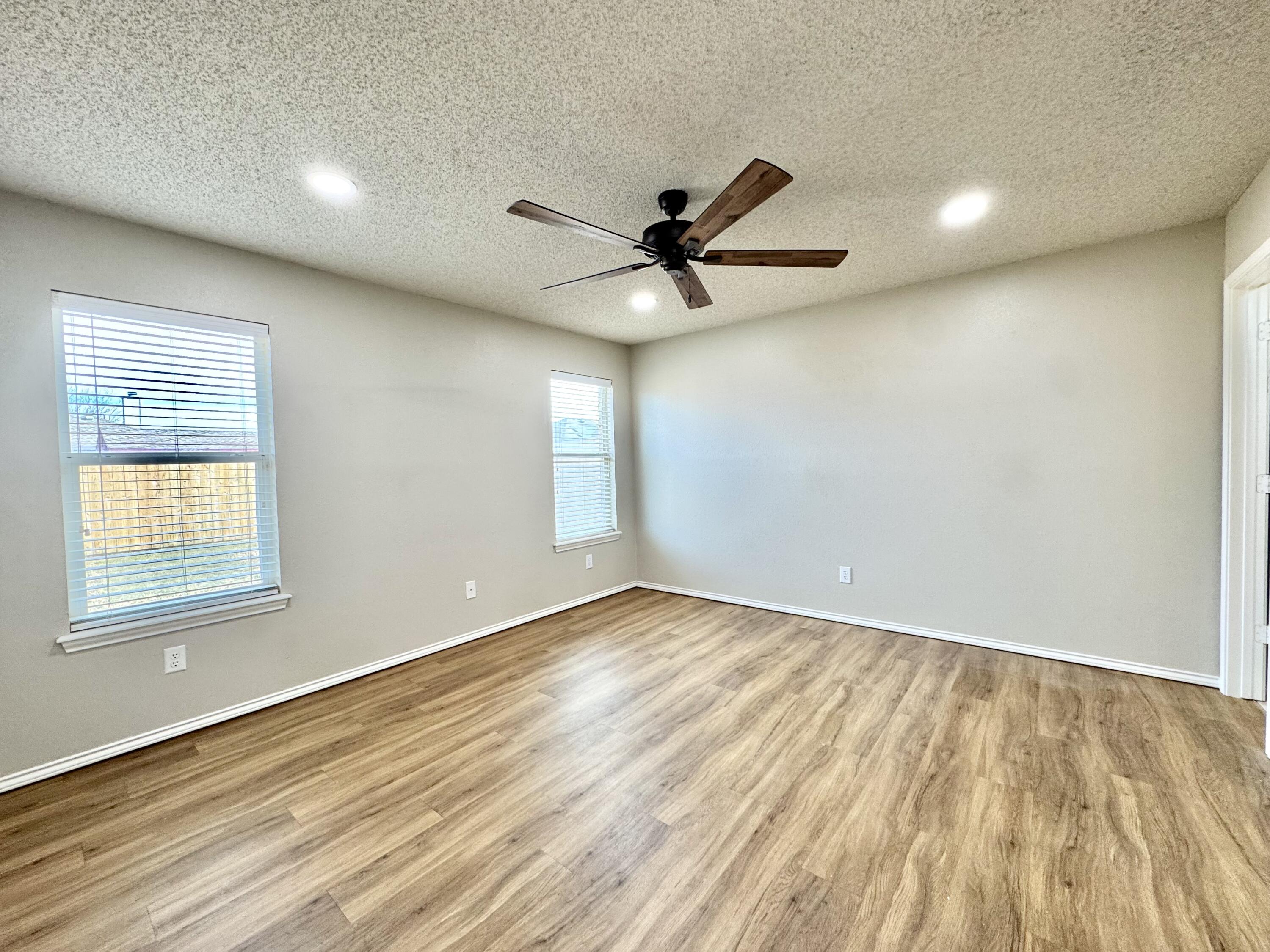 6536 7th Street Lubbock, TX 79416 - Photo 10 of 20 an empty room with wooden floor and windows