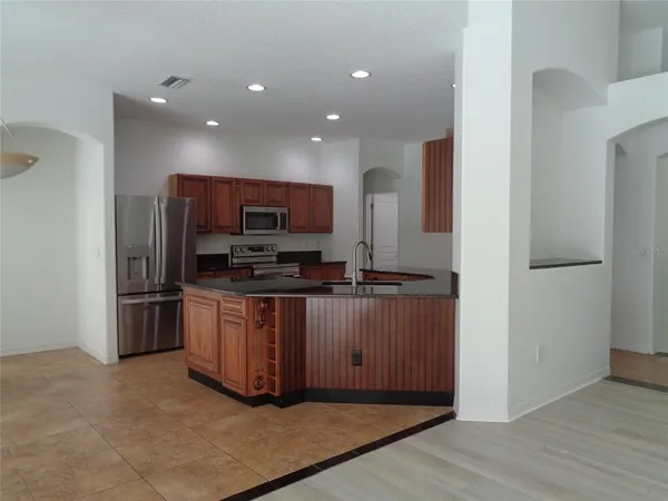a kitchen with stainless steel appliances granite countertop a refrigerator and a stove top oven