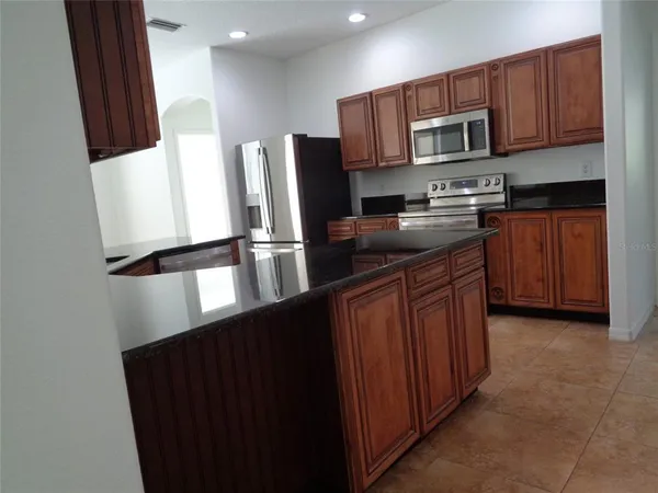 a kitchen with stainless steel appliances a refrigerator and a stove top oven