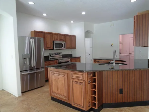 a kitchen with stainless steel appliances granite countertop a sink a microwave a stove and a refrigerator