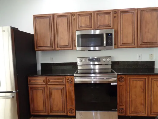 a kitchen with stainless steel appliances granite countertop a refrigerator stove and microwave