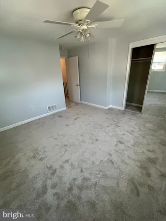an empty room with fan and entrance