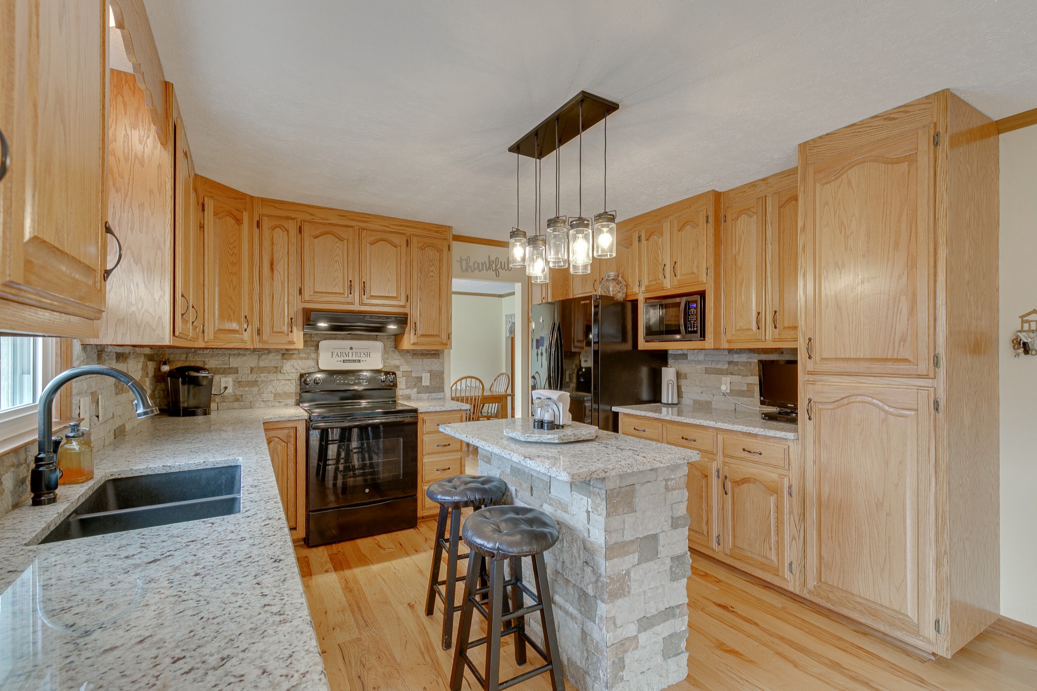 1872 Clara Mathis Road Spring Hill, TN 37174 - Photo 10 of 40 a kitchen with kitchen island granite countertop a stove top oven a sink a counter space and cabinets