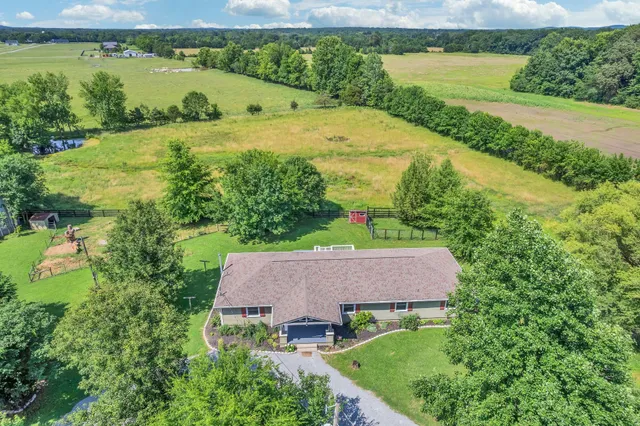 an aerial view of a house with a garden and lake view