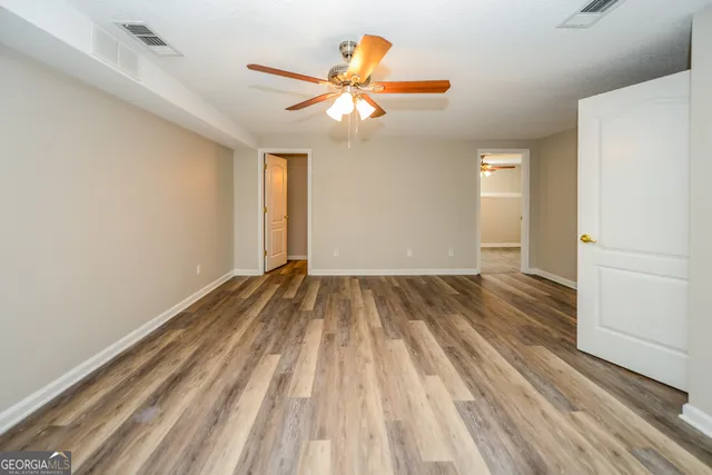 a view of empty room with wooden floor