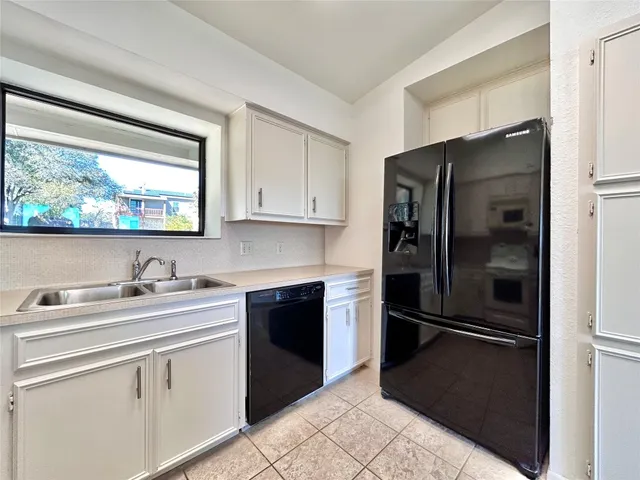 a kitchen with a refrigerator sink and cabinets
