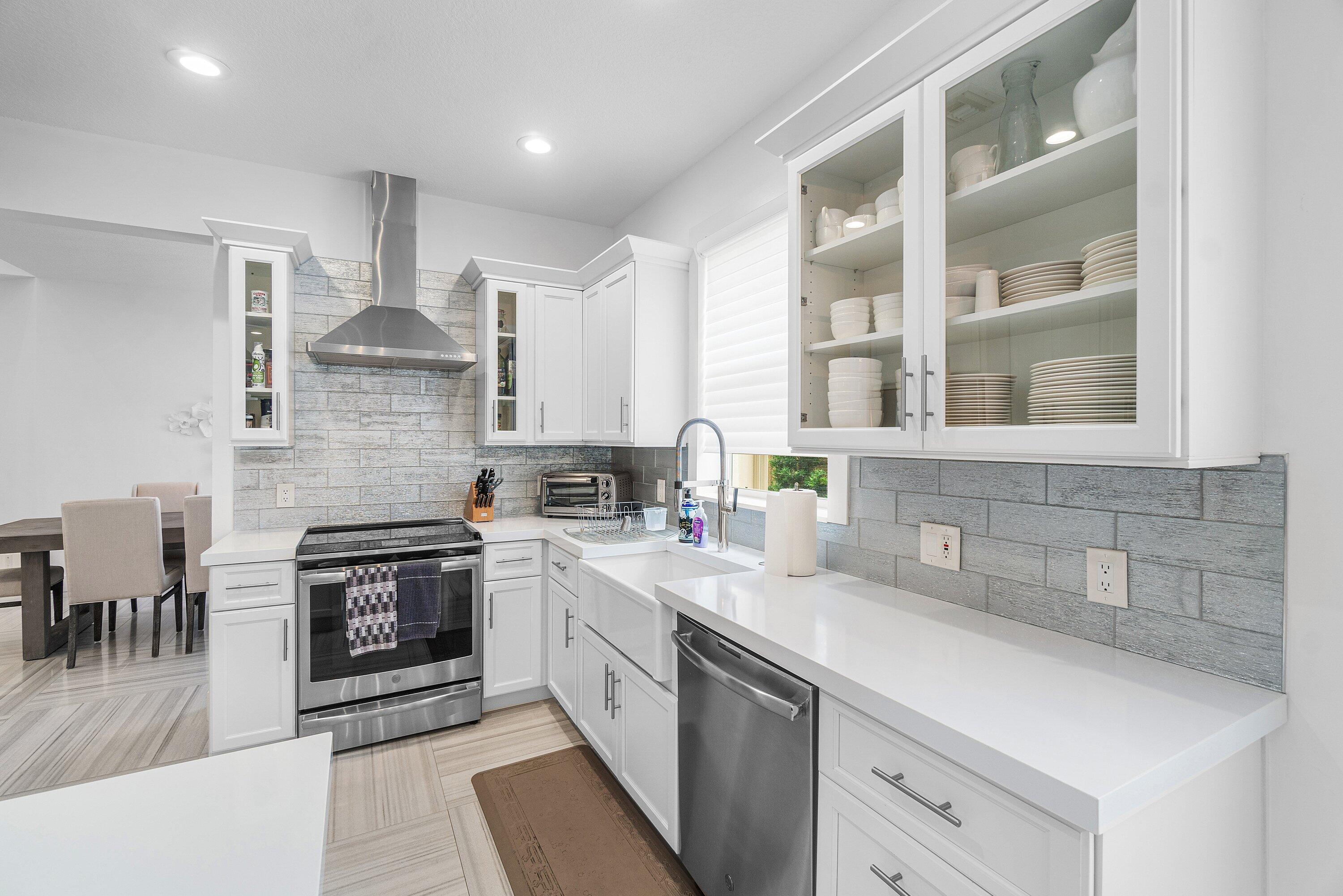 2404 Northwest 67th Street Boca Raton, FL 33496 - Photo 10 of 74 a kitchen with stainless steel appliances granite countertop a sink stove and cabinets