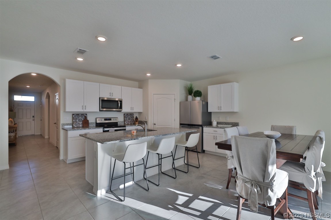 421 Anne Street DeLand, FL 32724 - Photo 5 of 44 a view of kitchen with stainless steel appliances wooden floor dining table and chairs