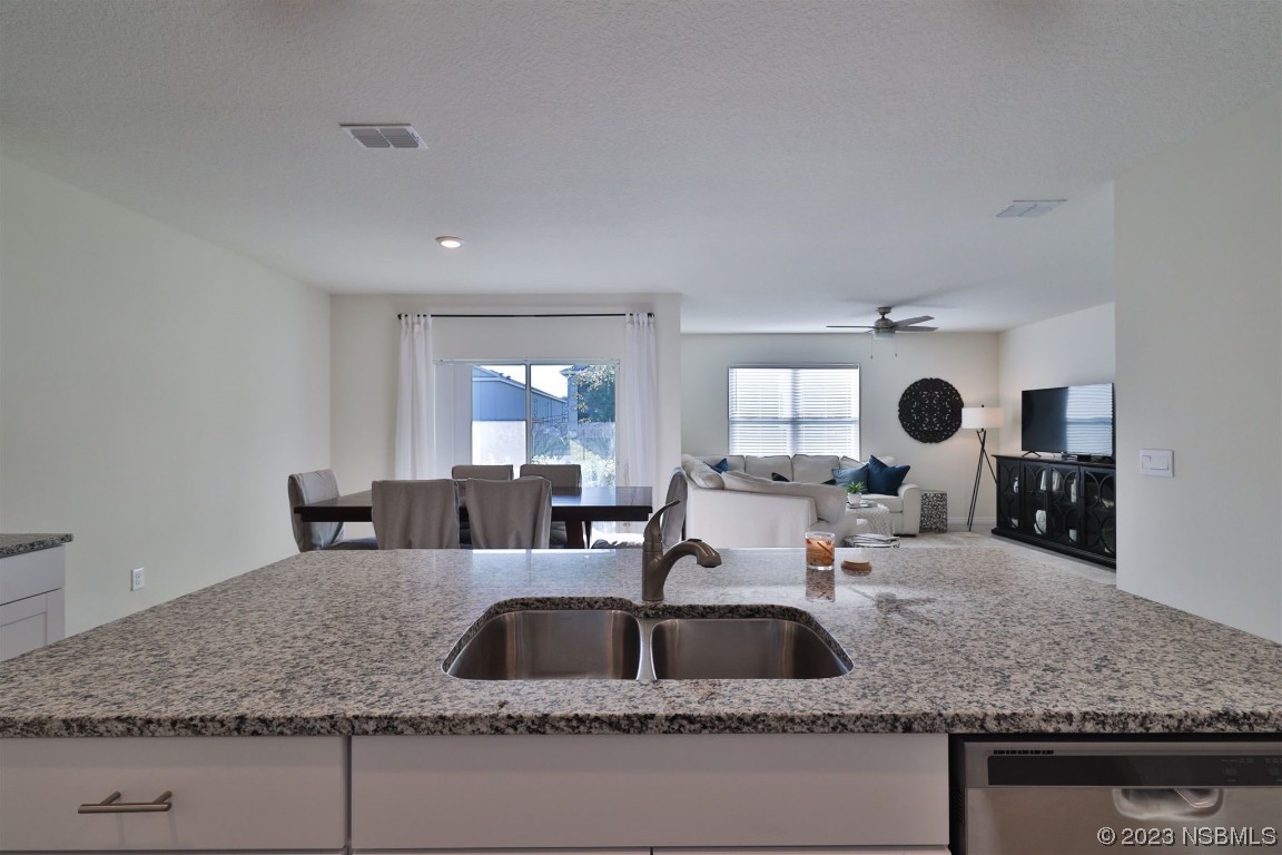 421 Anne Street DeLand, FL 32724 - Photo 7 of 44 a kitchen with granite countertop a sink and white cabinets