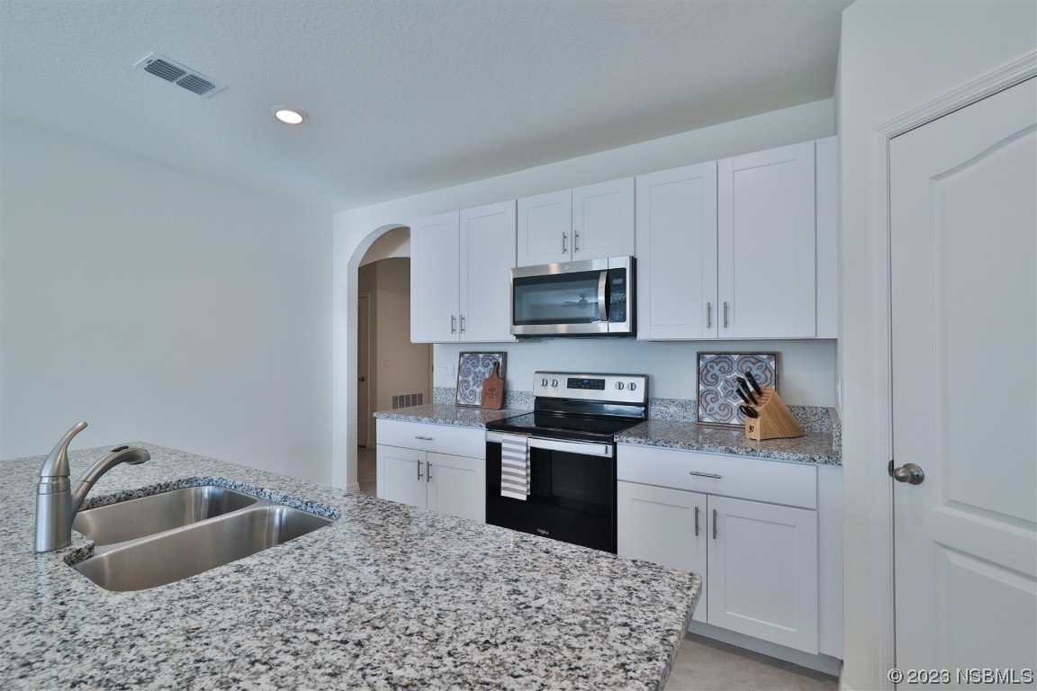 421 Anne Street DeLand, FL 32724 - Photo 8 of 44 a kitchen with white cabinets sink and stainless steel appliances