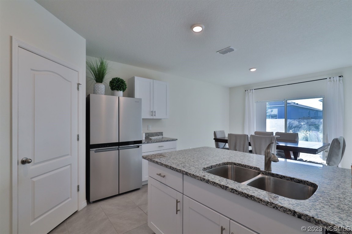 421 Anne Street DeLand, FL 32724 - Photo 9 of 44 a kitchen with granite countertop a sink and a refrigerator