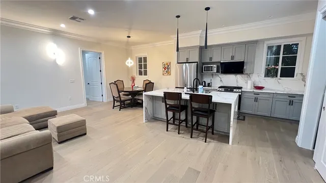 a living room with furniture a flat screen tv and kitchen view