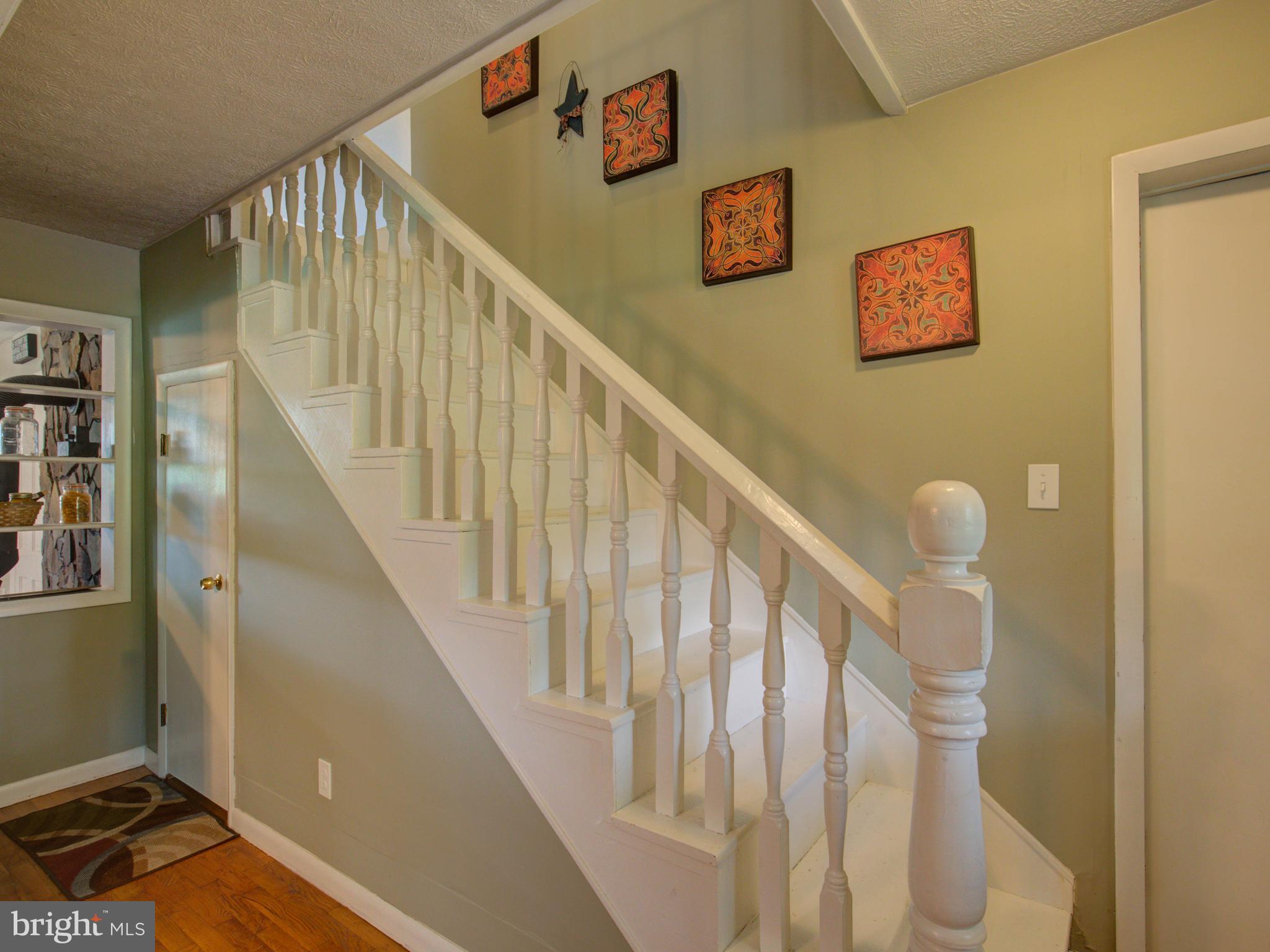 2902 Timber Ridge Road Berkeley Springs, WV 25411 - Photo 4 of 30 a view of staircase with lots of frames on wall and white walls