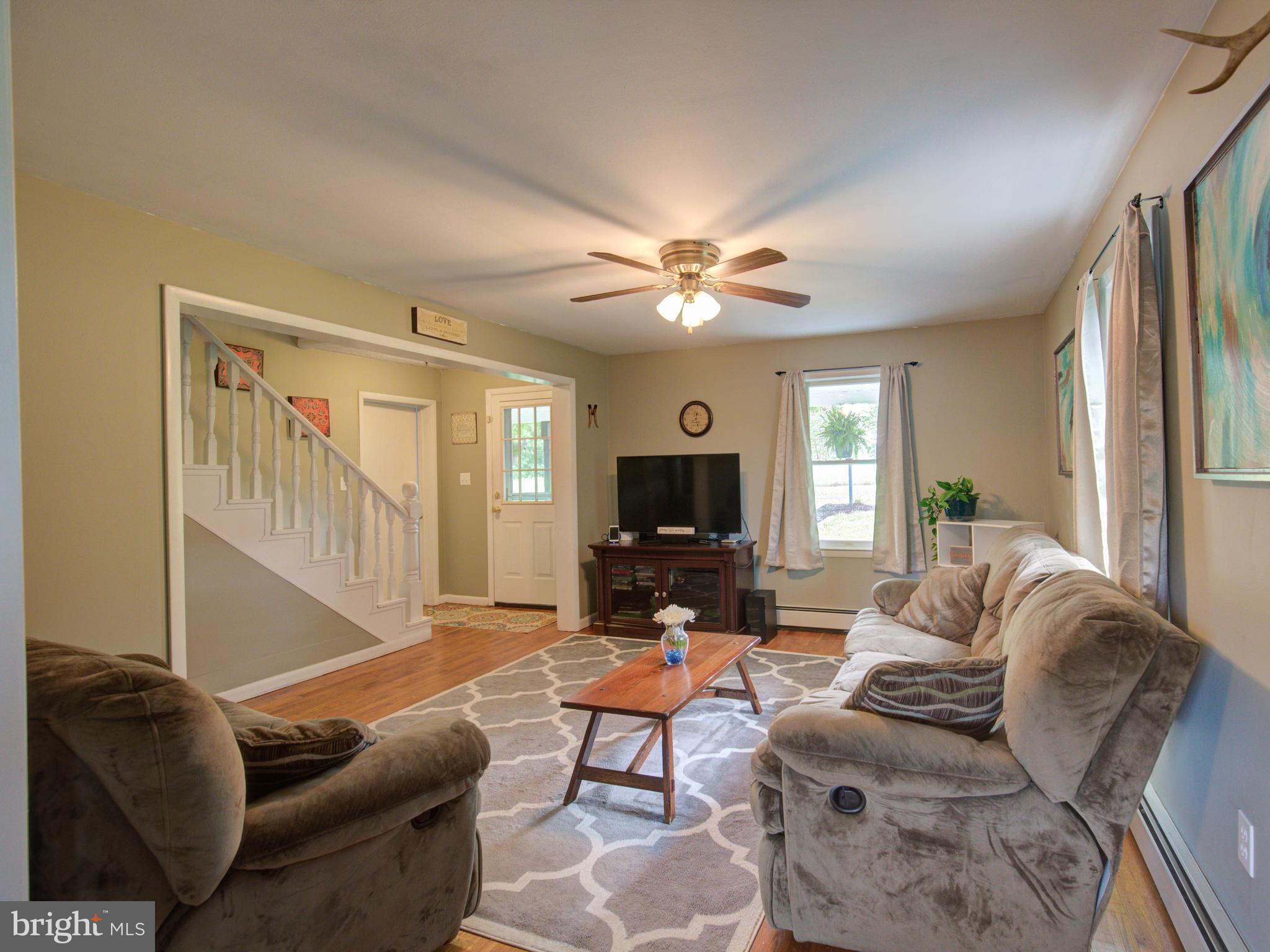 2902 Timber Ridge Road Berkeley Springs, WV 25411 - Photo 7 of 30 a living room with furniture a ceiling fan and a window