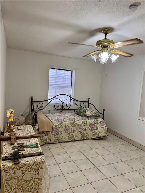 3813 North Taylor Road Mission, TX 78573 - Photo 18 of 29 a bedroom with a bed and a chandelier