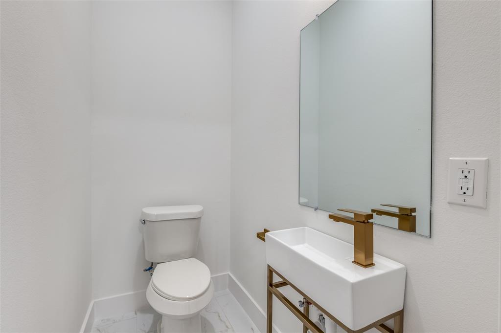 2607 Calvin Street, Unit 3 Dallas, TX 75204 - Photo 17 of 26 a white toilet sitting next to a bathroom sink