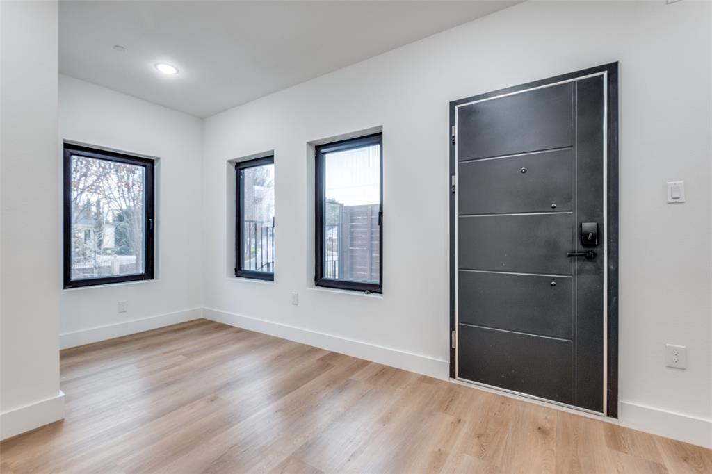 2607 Calvin Street, Unit 3 Dallas, TX 75204 - Photo 3 of 26 a view of an empty room with wooden floor and a window