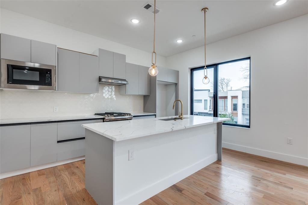 2607 Calvin Street, Unit 3 Dallas, TX 75204 - Photo 6 of 26 a kitchen with stainless steel appliances granite countertop a sink a stove and a refrigerator