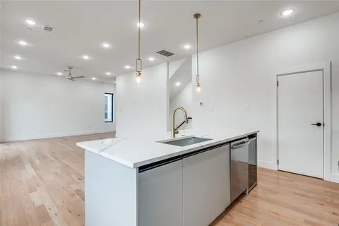 a kitchen with a sink a mirror and wooden floor