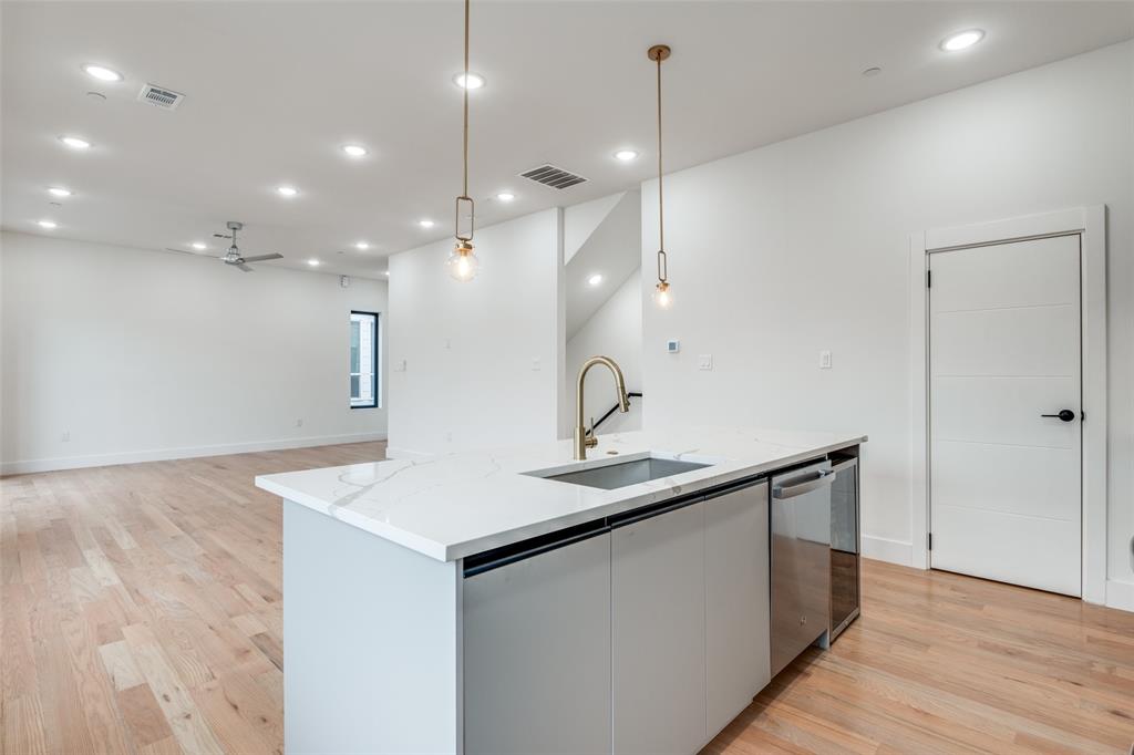2607 Calvin Street, Unit 3 Dallas, TX 75204 - Photo 8 of 26 a kitchen with a sink a mirror and wooden floor