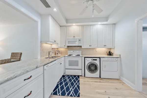 a kitchen with granite countertop a sink a stove and cabinets
