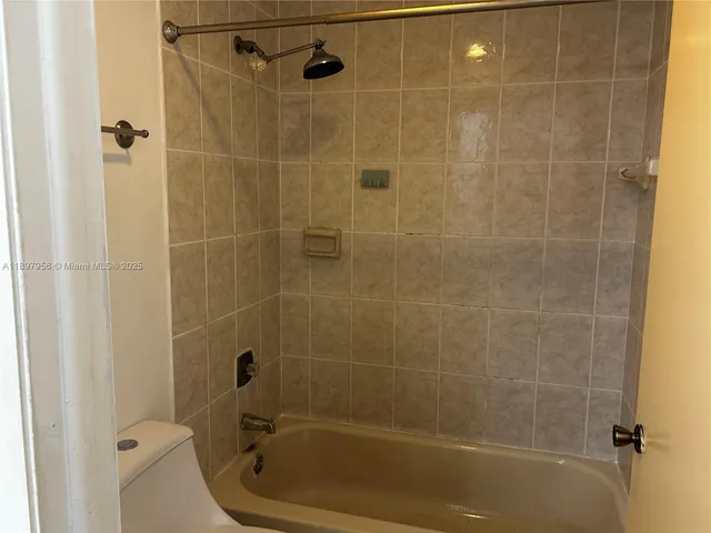 a bathroom with a granite countertop sink a toilet and shower