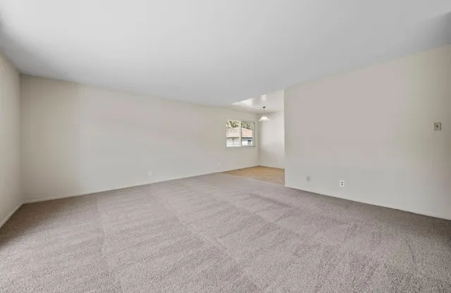 an empty room with windows and cabinet