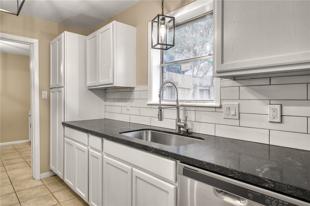 1212 Ridgefield Circle South College Station, TX 77840 - Photo 14 of 23 a kitchen with stainless steel appliances granite countertop a sink and white cabinets