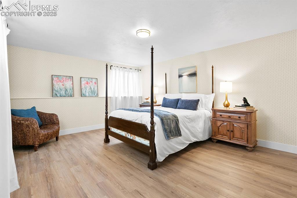 1225 Montezuma Road Colorado Springs, CO 80920 - Photo 13 of 44 Bedroom with wallpapered walls and light wood-style floors