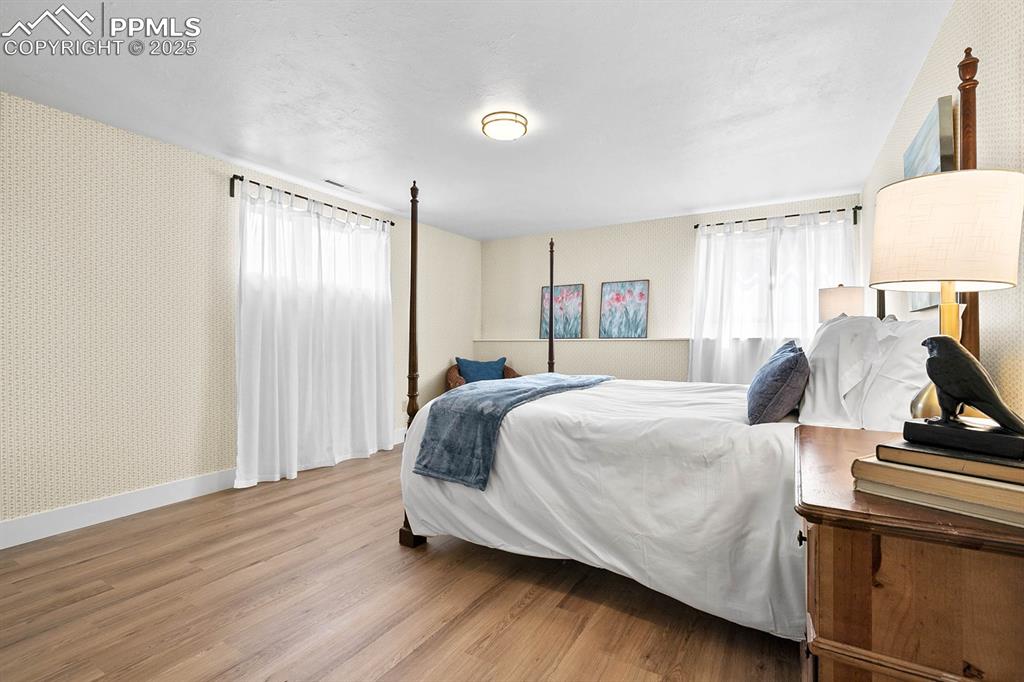 1225 Montezuma Road Colorado Springs, CO 80920 - Photo 15 of 44 Bedroom with wallpapered walls and wood finished floors