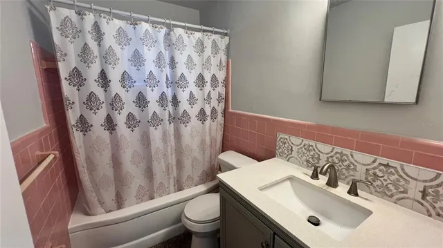 an empty room with a chandelier fan and windows