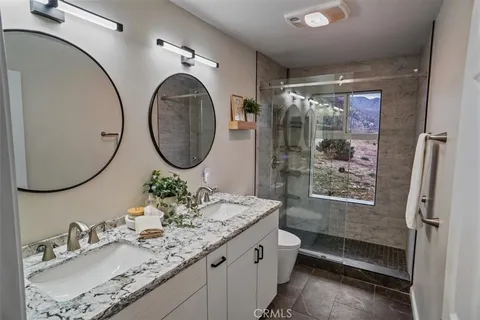 a bathroom with a granite countertop sink mirror toilet and shower