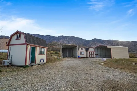 a view of a house with a yard and large tree