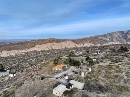 a view of a dry yard with wooden fence
