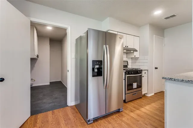 a kitchen with stainless steel appliances a refrigerator and a stove top oven