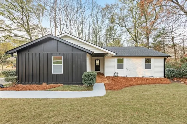 a front view of house with yard and trees around
