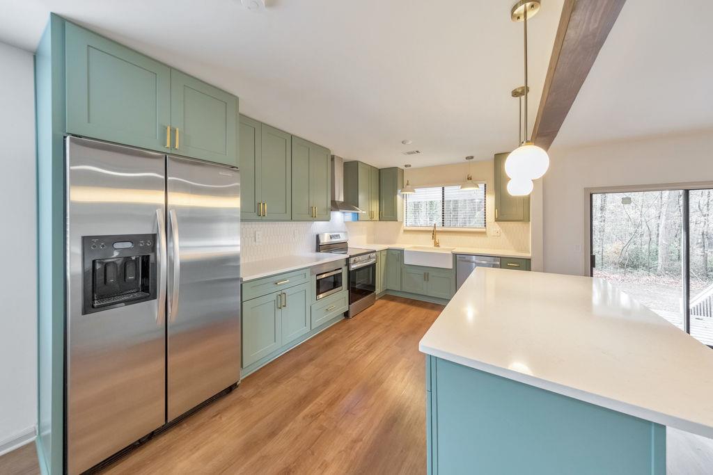 1535 Rucker Road Alpharetta, GA 30009 - Photo 14 of 42 a kitchen with stainless steel appliances granite countertop a refrigerator a sink a stove and white cabinets with wooden floor