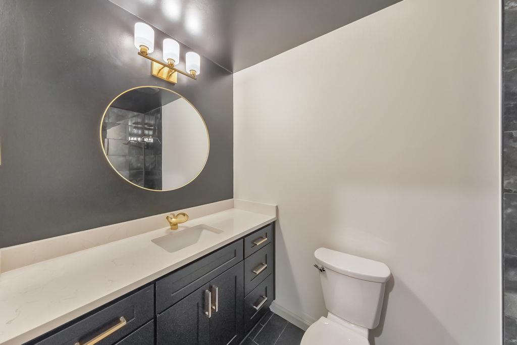 1535 Rucker Road Alpharetta, GA 30009 - Photo 29 of 42 a bathroom with a toilet sink vanity and mirror